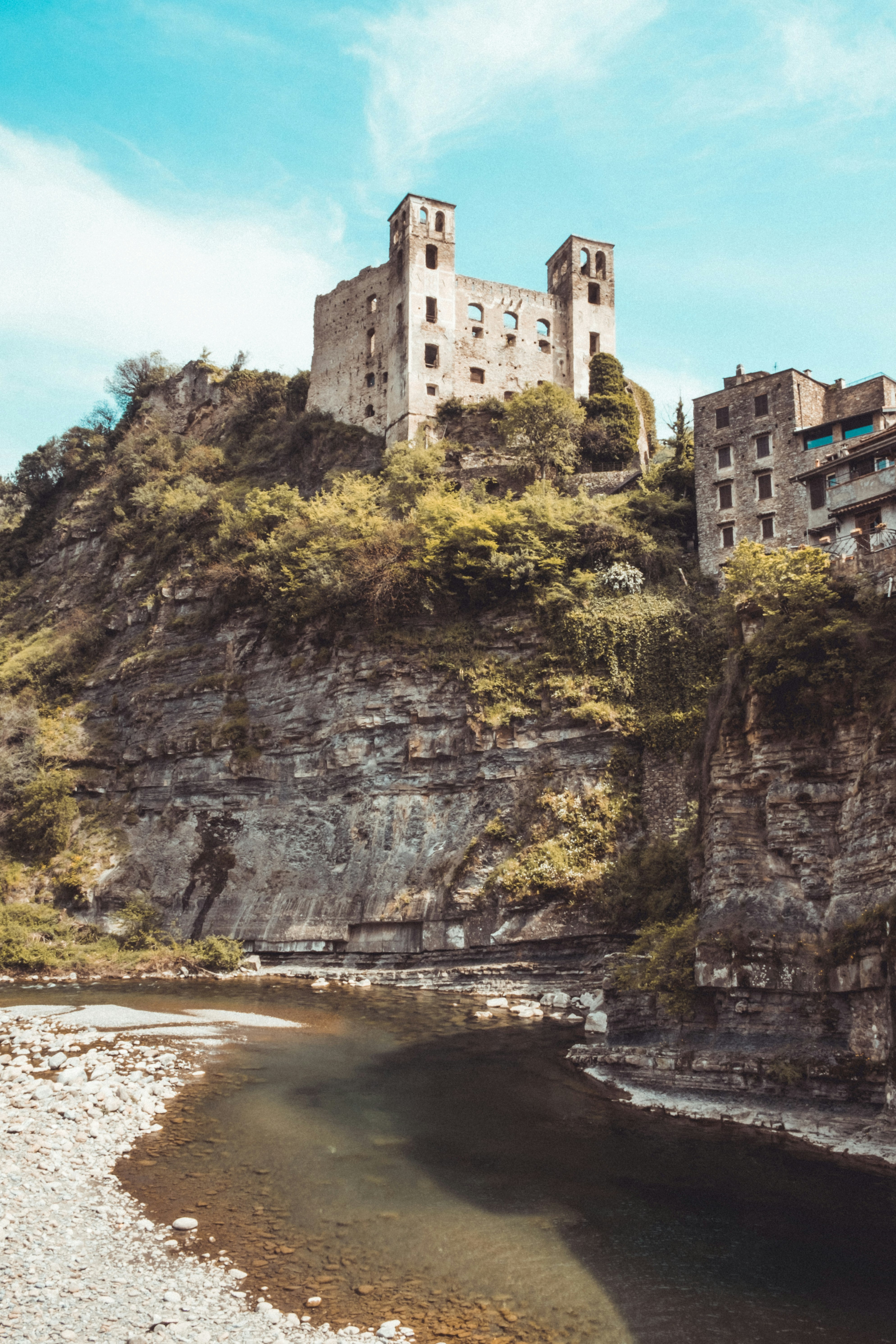 white concrete building on cliff near body of water during daytime